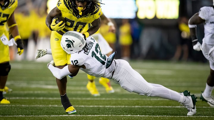 Oregon Ducks running back Jordan James is tackled by Michigan State Spartans defensive back Justin Denson Jr. as the Ducks host the Spartans Friday, Oct. 4, 2024 at Autzen Stadium in Eugene, Ore.