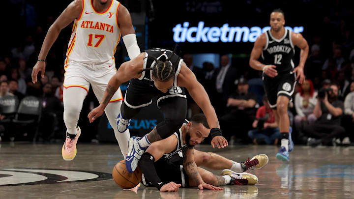 Apr 10, 2025; Brooklyn, New York, USA; Atlanta Hawks forward Onyeka Okongwu (17) fights for a loose ball against Brooklyn Nets forward Tosan Evbuomwan (12) and guard Tyrese Martin (13) during the second quarter at Barclays Center. Mandatory Credit: Brad Penner-Imagn Images