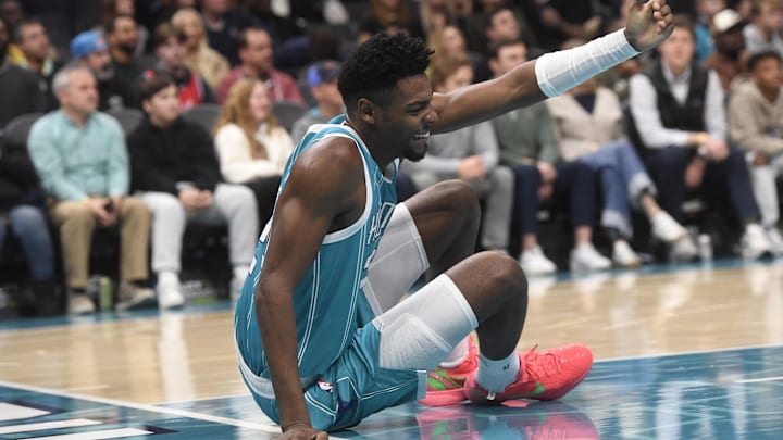 Dec 16, 2024; Charlotte, North Carolina, USA;  Charlotte Hornets forward Brandon Miller (24) signals for someone to help him up after a fall during the second half against the Philadelphia 76ers at the Spectrum Center. Mandatory Credit: Sam Sharpe-Imagn Images