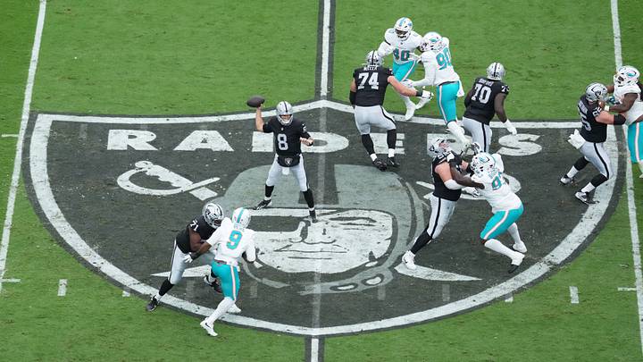 A general overall view as Las Vegas Raiders quarterback Kirk Cousins (8) throws in the first quarter on the Raiders shield logo at midfield against the Miami Dolphins at Allegiant Stadium. A general overall view as Las Vegas Raiders quarterback Kirk Cousins (8) throws in the first quarter on the Raiders shield logo at midfield against the Miami Dolphins at Allegiant Stadium.