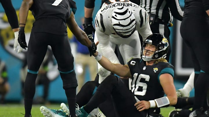 Jacksonville Jaguars wide receiver Zay Jones (7) and Cincinnati Bengals defensive end Trey Hendrickson (91) try to help Jacksonville quarterback Trevor Lawrence (16) after he injured his right ankle on a fourth quarter play which took him out of the game. The Jacksonville Jaguars hosted the Cincinnati Bengals at EverBank Stadium in Jacksonville, Florida for Monday Night Football, December 4, 2023. The Jaguars were tied 14 to 14 at the end of the first half an fell in overtime with a final score