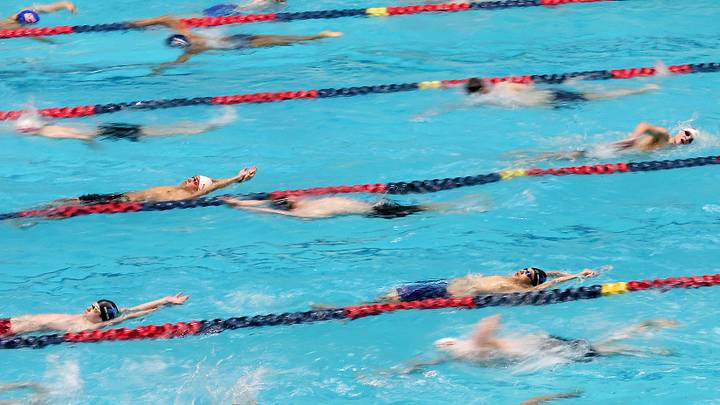 Swimmers warmup in the pool prior to the start of the 1A/2A State Swim prelims at the King County Aquatic Center in Federal Way, Wash. on Friday, Feb. 21, 2025.