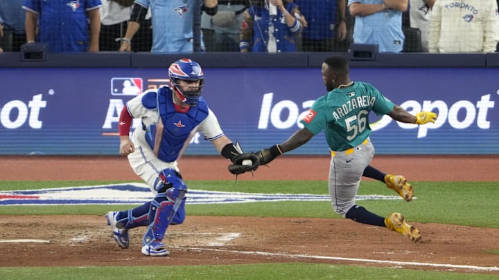 Oct 19, 2025; Toronto, Ontario, CAN; Seattle Mariners left fielder Randy Arozarena (56) runs home to score against Toronto Blue Jays catcher Alejandro Kirk (30) in the sixth inning during game six of the ALCS round for the 2025 MLB playoffs at Rogers Centre. Mandatory Credit: Kevin Sousa-Imagn Images Oct 19, 2025; Toronto, Ontario, CAN; Seattle Mariners left fielder Randy Arozarena (56) runs home to score against Toronto Blue Jays catcher Alejandro Kirk (30) in the sixth inning during game six of the ALCS round for the 2025 MLB playoffs at Rogers Centre. Mandatory Credit: Kevin Sousa-Imagn Images