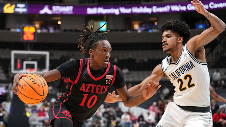 Dec 21, 2024; San Jose, California, USA; San Diego State Aztecs guard BJ Davis (10) dribbles against California Golden Bears guard Christian Tucker (22) during the first half at SAP Center. Mandatory Credit: Darren Yamashita-Imagn Images