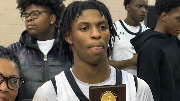 Tavares "Boogie" Vaughn-Cooper hold a plaque commemorating his 1,000th career high school point following a recent Richard Montgomery boys basketball game.