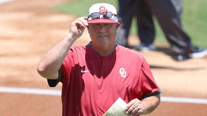 Oklahoma coach Skip Johnson returns to the dugout after exchanging lineup cards.