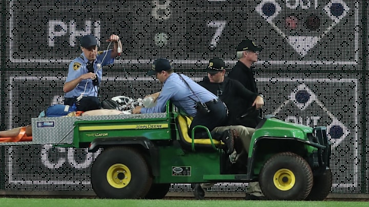 Apr 30, 2025; Pittsburgh, Pennsylvania, USA;  Stadium security and Pittsburgh Pirates medical personnel cart a fan who fell from the stands to the field to an ambulance as the Pirates batted against the Chicago Cubs during the seventh inningat PNC Park. Mandatory Credit: Charles LeClaire-Imagn Images