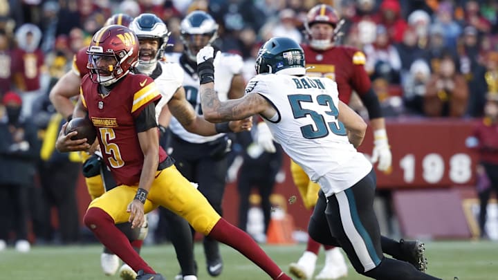 Dec 22, 2024; Landover, Maryland, USA; Washington Commanders quarterback Jayden Daniels (5) runs with the ball as Philadelphia Eagles linebacker Zack Baun (53) chases during the third quarter at Northwest Stadium. Mandatory Credit: Geoff Burke-Imagn Images