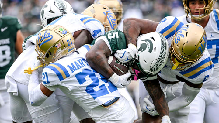 Michigan State's Makhi Frazier, center, is tackled by UCLA after a gain during the first quarter on Saturday, Oct. 11, 2025, at Spartan Stadium in East Lansing. Michigan State's Makhi Frazier, center, is tackled by UCLA after a gain during the first quarter on Saturday, Oct. 11, 2025, at Spartan Stadium in East Lansing.