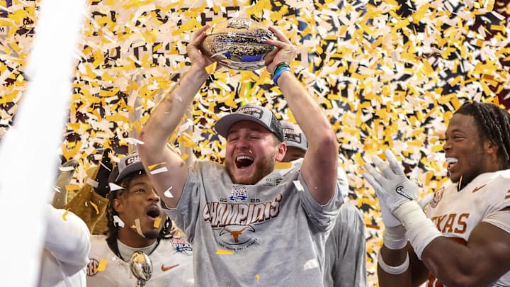 Jan 1, 2025; Atlanta, GA, USA; Texas Longhorns quarterback Quinn Ewers (3) holds up the trophy after a victory over the Arizona State Sun Devils in the Peach Bowl at Mercedes-Benz Stadium.