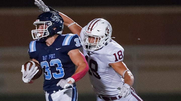 De Pere High School's Cayden Cavanaugh (18) attempts to tackle Bay Port's Brady Moon (33) during a Fox River Classic Conference (North Division) game on Friday, October 3, 2025.