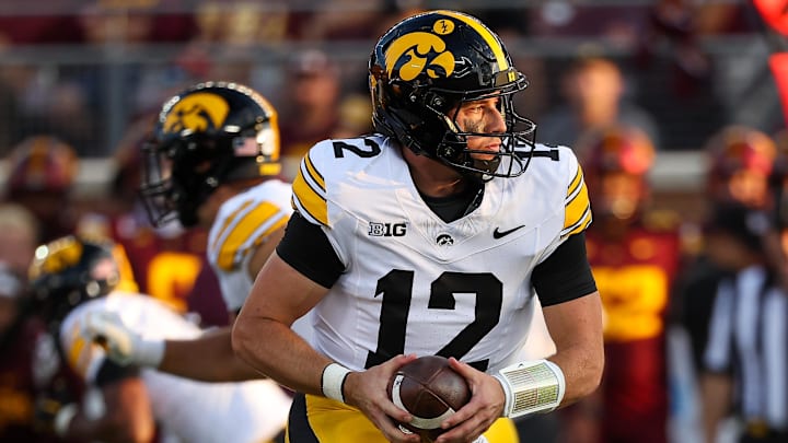 Sep 21, 2024; Minneapolis, Minnesota, USA; Iowa Hawkeyes quarterback Cade McNamara (12) takes a snap against the Minnesota Golden Gophers during the first half at Huntington Bank Stadium.