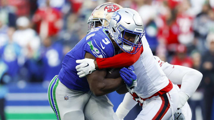 Oct 10, 2024; Seattle, Washington, USA; San Francisco 49ers cornerback Deommodore Lenoir (2) tackles Seattle Seahawks running back Kenneth Walker III (9) during the first quarter at Lumen Field. Mandatory Credit: Joe Nicholson-Imagn Images