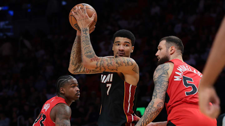 Dec 15, 2025; Miami, Florida, USA; Miami Heat center Kel'El Ware (7) protects the basketball from Toronto Raptors forward Sandro Mamukelashvili (54) and guard Jamal Shead (23) during the third quarter at Kaseya Center. Mandatory Credit: Sam Navarro-Imagn Images