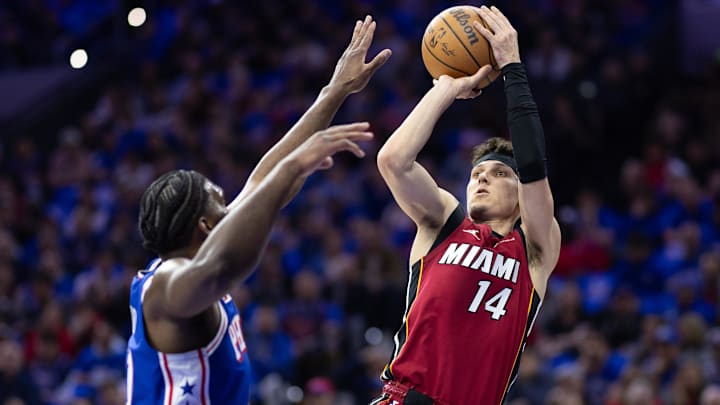 Apr 17, 2024; Philadelphia, Pennsylvania, USA; Miami Heat guard Tyler Herro (14) shoots past Philadelphia 76ers center Joel Embiid (21) during the first quarter of a play-in game of the 2024 NBA playoffs at Wells Fargo Center. Mandatory Credit: Bill Streicher-Imagn Images