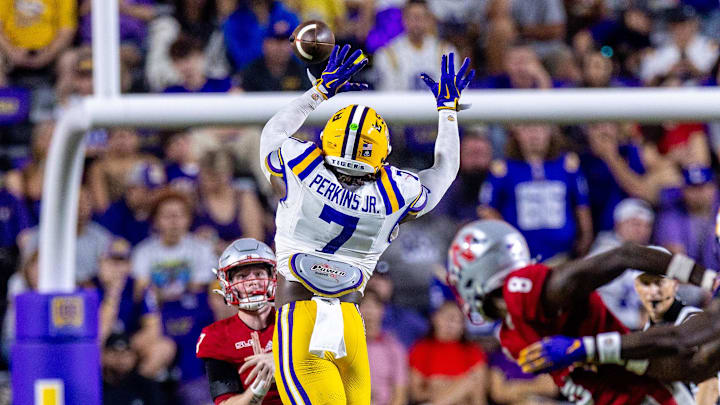 Sep 7, 2024; Baton Rouge, Louisiana, USA; Nicholls State Colonels quarterback Pat McQuaide (7) rolls out of the pocket against LSU Tigers linebacker Harold Perkins Jr. (7) during the second half at Tiger Stadium.