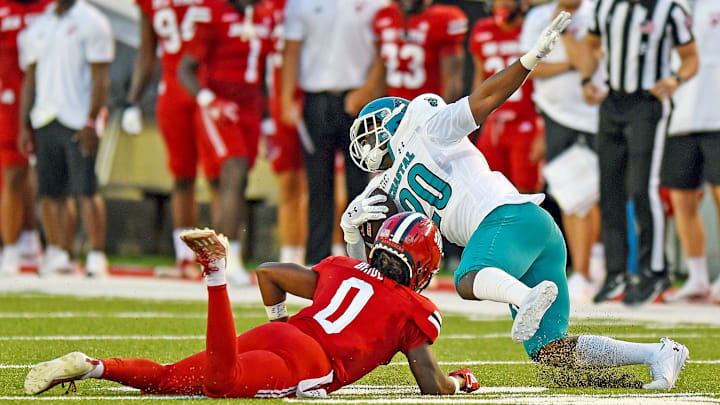 Coastal Carolina's Christian Washington tries to evade the tackle of Jacksonville State's Tyler Bride. Coastal Carolina's Christian Washington tries to evade the tackle of Jacksonville State's Tyler Bride.