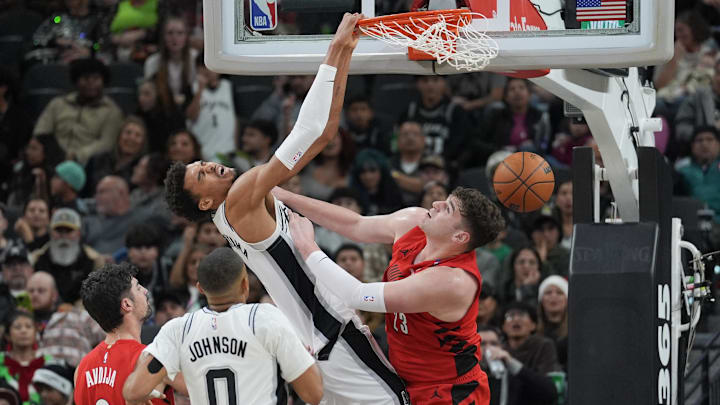 Dec 21, 2024; San Antonio, Texas, USA; San Antonio Spurs center Victor Wembanyama (1) dunks and is fouled by Portland Trail Blazers center Donovan Clingan (23) in the first half at Frost Bank Center.