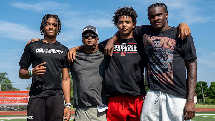From left to right, Donald Tabron II, 16, Donovan Dooley, 40, owner and founder of Quarterback University, Trae Taylor, 16, and Bryce Underwood, 17, take a photo together after participating in a private workout in Detroit on Saturday, June 21, 2025.