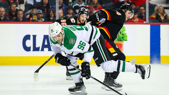 Mar 27, 2025; Calgary, Alberta, CAN; Dallas Stars right wing Mikko Rantanen (96) controls the puck against Calgary Flames defenseman Joel Hanley (44) during the third period at Scotiabank Saddledome. Mandatory Credit: Sergei Belski-Imagn Images