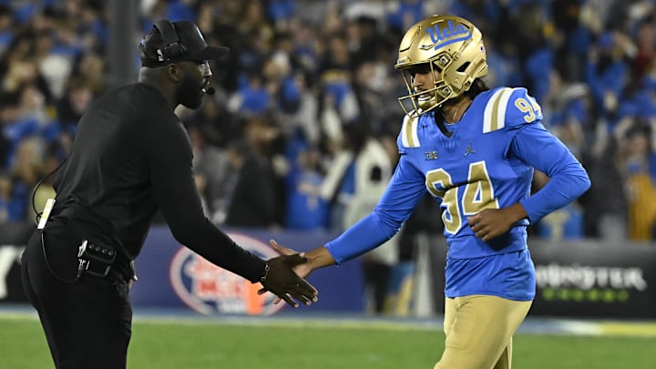 Nov 23, 2024; Pasadena, California, USA; UCLA Bruins place kicker Mateen Bhaghani (94) high fives head coach DeShaun Foster after hitting a first quarter field goal against the USC Trojans at Rose Bowl. Mandatory Credit: Robert Hanashiro-Imagn Images