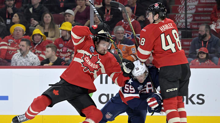 Feb 15, 2025; Montreal, Quebec, CAN; [Imagn Images direct customers only] Team Canada forward Mark Stone (61) and teammate Team Canada defenseman Thomas Harley (48) check Team United States forward Jake Guentzel (59) in the third period during a 4 Nations Face-Off ice hockey game at the Bell Centre. Mandatory Credit: Eric Bolte-Imagn Images