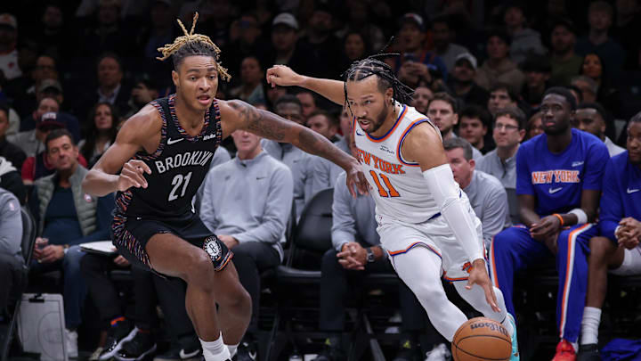 Nov 24, 2025; Brooklyn, New York, USA; New York Knicks guard Jalen Brunson (11) dribbles against Brooklyn Nets forward Noah Clowney (21) during the first quarter at Barclays Center. Mandatory Credit: Vincent Carchietta-Imagn Images