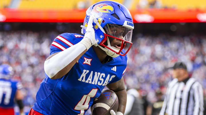 Nov 23, 2024; Kansas City, Missouri, USA;  Kansas running back Devin Neal (4) reacts to fans after scoring a rushing touchdown during the 2nd quarter between the Kansas Jayhawks and the Colorado Buffaloes at GEHA Field at Arrowhead Stadium. Mandatory Credit: Nick Tre. Smith-Imagn Images