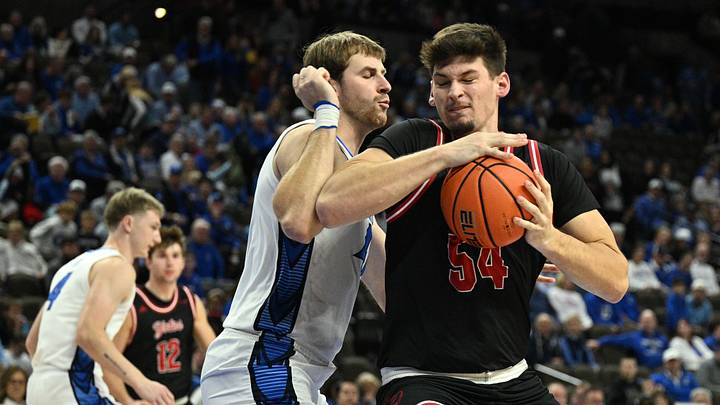 Nov 5, 2025; Omaha, Nebraska, USA;  South Dakota Coyotes center Cameron Fens (54) drives against Creighton Bluejays forward Isaac Traudt (41) during the first half at CHI Health Center Omaha. Mandatory Credit: Steven Branscombe-Imagn Images