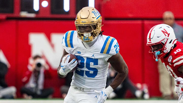 Nov 2, 2024; Lincoln, Nebraska, USA; UCLA Bruins running back T.J. Harden (25) runs the ball against Nebraska Cornhuskers defensive lineman Jimari Butler (10) during the third quarter at Memorial Stadium. Mandatory Credit: Dylan Widger-Imagn Images Nov 2, 2024; Lincoln, Nebraska, USA; UCLA Bruins running back T.J. Harden (25) runs the ball against Nebraska Cornhuskers defensive lineman Jimari Butler (10) during the third quarter at Memorial Stadium. Mandatory Credit: Dylan Widger-Imagn Images