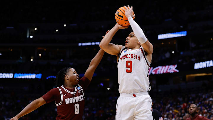 Mar 20, 2025; Denver, CO, USA; Wisconsin Badgers guard John Tonje (9) shoots the ball against Montana Grizzlies guard Money Williams (0) during the first half in the first round of the NCAA Tournament at Ball Arena. Mandatory Credit: Isaiah J. Downing-Imagn Images