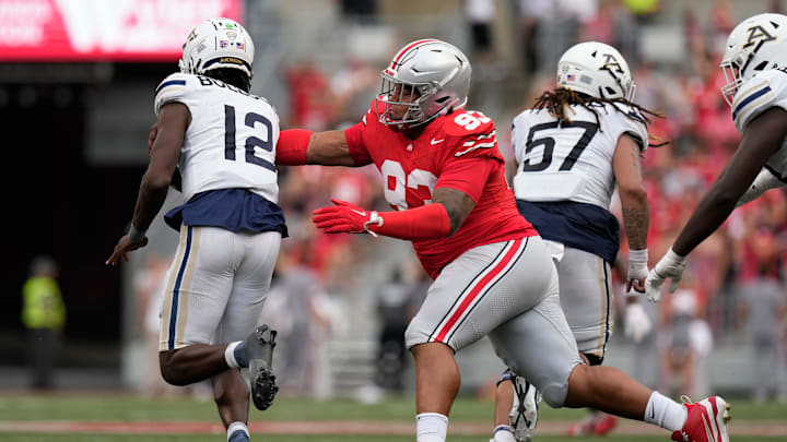 Ohio State Buckeyes defensive tackle Hero Kanu (93) reaches to tackle Akron Zips quarterback Tahj Bullock (12) during the second half of the NCAA football game at Ohio Stadium. Ohio State won 52-6.