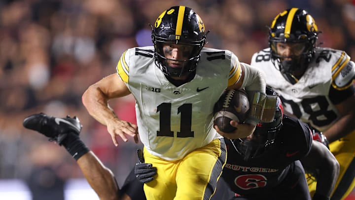 Sep 19, 2025; Piscataway, New Jersey, USA; Iowa Hawkeyes quarterback Mark Gronowski (11) fights for rushing yards as Rutgers Scarlet Knights linebacker Abram Wright (6) tackles during the second half at SHI Stadium. Mandatory Credit: Vincent Carchietta-Imagn Images