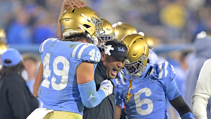 Nov 8, 2024; Pasadena, California, USA;   UCLA Bruins defensive coordinator Ikaika Malloe, center, celebrates with linebacker Carson Schwesinger (49) defensive back Jaylin Davies (6) after an interception in the second half against the Iowa Hawkeyes at the Rose Bowl. Mandatory Credit: Jayne Kamin-Oncea-Imagn Images