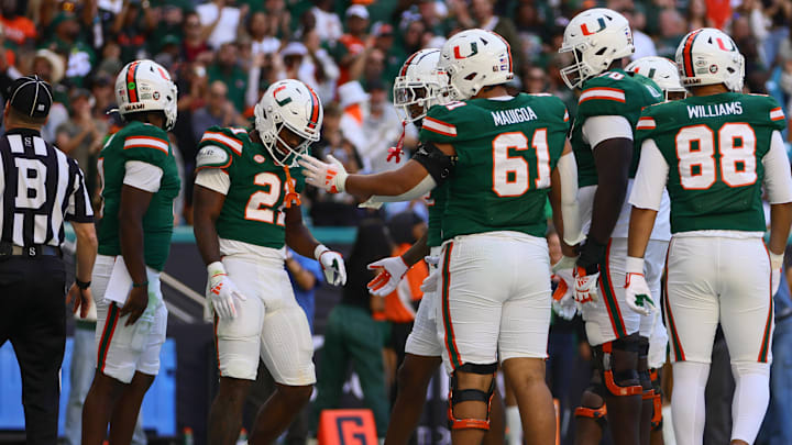 Nov 23, 2024; Miami Gardens, Florida, USA; Miami Hurricanes running back Jordan Lyle (21) celebrates with teammates after scoring a touchdown against the Wake Forest Demon Deacons during the fourth quarter at Hard Rock Stadium. Mandatory Credit: Sam Navarro-Imagn Images Nov 23, 2024; Miami Gardens, Florida, USA; Miami Hurricanes running back Jordan Lyle (21) celebrates with teammates after scoring a touchdown against the Wake Forest Demon Deacons during the fourth quarter at Hard Rock Stadium. Mandatory Credit: Sam Navarro-Imagn Images