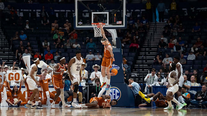 Texas Longhorns guard Chendall Weaver (2) hangs onto the rim during their second round game of the SEC Men's Basketball Tournament at Bridgestone Arena in Nashville, Tenn., Thursday, March 13, 2025.