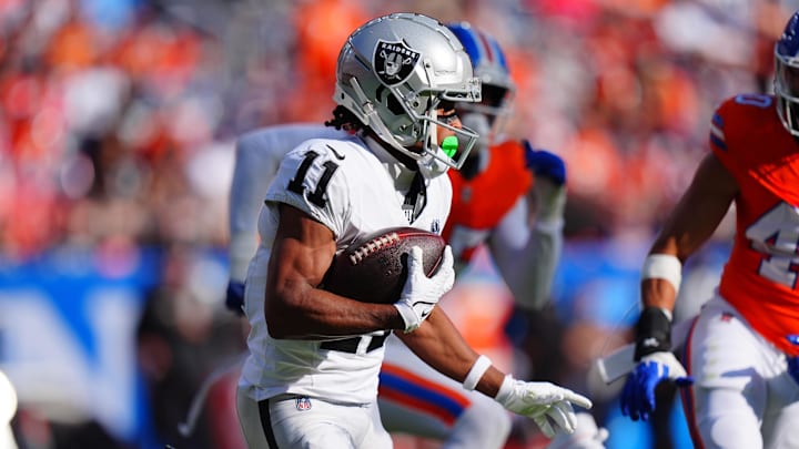 Oct 6, 2024; Denver, Colorado, USA; Las Vegas Raiders wide receiver Tre Tucker (11) carries the ball in the second half against the Denver Broncos at Empower Field at Mile High. Mandatory Credit: Ron Chenoy-Imagn Images