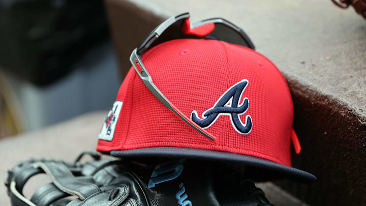 wMar 1, 2025; North Port, Florida, USA; A detail view of Atlanta Braves hat, sunglasses and glove in the dugout during the fifth inning at CoolToday Park. Mandatory Credit: Kim Klement Neitzel-Imagn Images