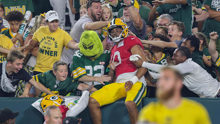 Green Bay Packers quarterback Jordan Love (10) does a Lambeau Leap after finishing a drill during Family Night on Saturday.