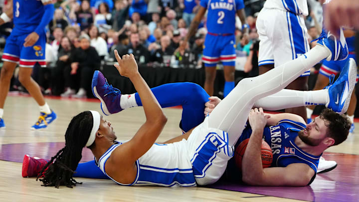 Nov 26, 2024; Las Vegas, Nevada, USA; Kansas Jayhawks center Hunter Dickinson (1) and Duke Blue Devils forward Maliq Brown (6) fall to the floor during the second half at T-Mobile Arena. Mandatory Credit: Stephen R. Sylvanie-Imagn Images