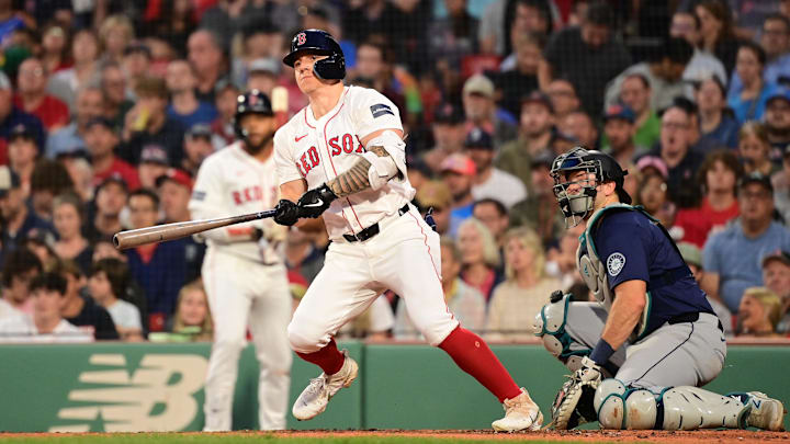 Jul 29, 2024; Boston, Massachusetts, USA; Boston Red Sox left fielder Tyler O'Neill (17) hits an RBI single against the Seattle Mariners during the third inning at Fenway Park. Mandatory Credit: Eric Canha-Imagn Images