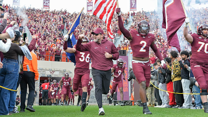Nov 9, 2024; Virginia Tech head coach Brent Pry leads his team onto the filed with wide receiver Takye Heath (2) before the game at Lane Stadium.