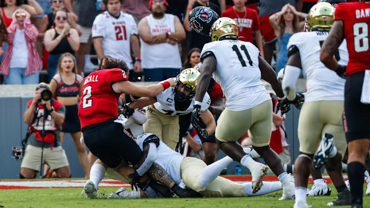 NC State quarterback Grayson McCall gets tackled without his helmet NC State quarterback Grayson McCall gets tackled without his helmet