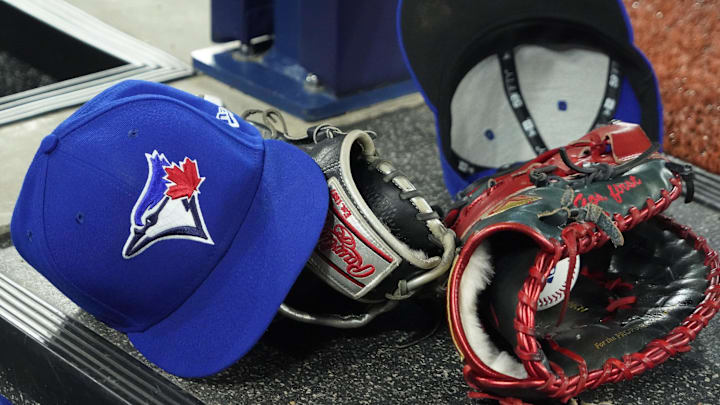 Apr 27, 2024; Toronto, Ontario, CAN; A pair of Toronto Blue Jays hats and gloves in the dugout during the first inning against the Los Angeles Dodgers at Rogers Centre. Mandatory Credit: John E. Sokolowski-Imagn Images