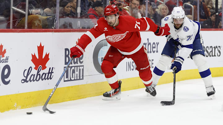 Feb 8, 2025; Detroit, Michigan, USA;  Detroit Red Wings center Dylan Larkin (71) skates with the puck chased by Tampa Bay Lightning defenseman Victor Hedman (77) in the second period at Little Caesars Arena. Mandatory Credit: Rick Osentoski-Imagn Images