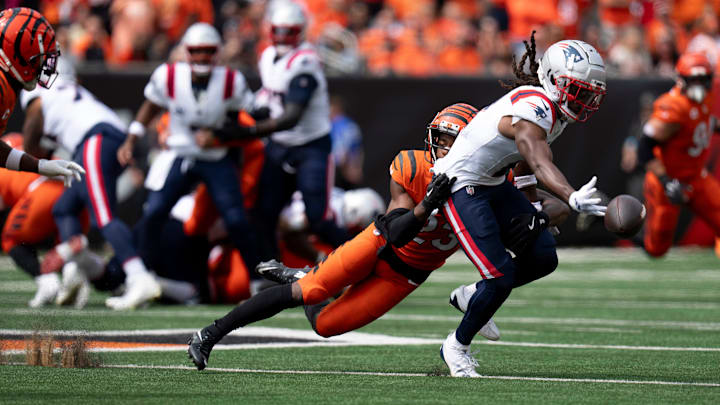 Cincinnati Bengals cornerback Dax Hill (23) hits New England Patriots wide receiver K.J. Osborn (2) as he drops a pass in the first quarter of the NFL game at Paycor Stadium in Cincinnati on Sunday, Sept. 8, 2024.