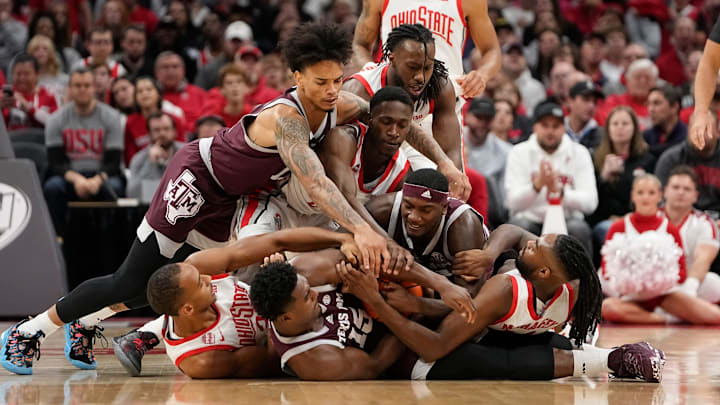 Nov 10, 2023; Columbus, Ohio, USA; Ohio State Buckeyes and Texas A&M Aggies players dive on a loose ball during the first half of the NCAA basketball game at Value City Arena.