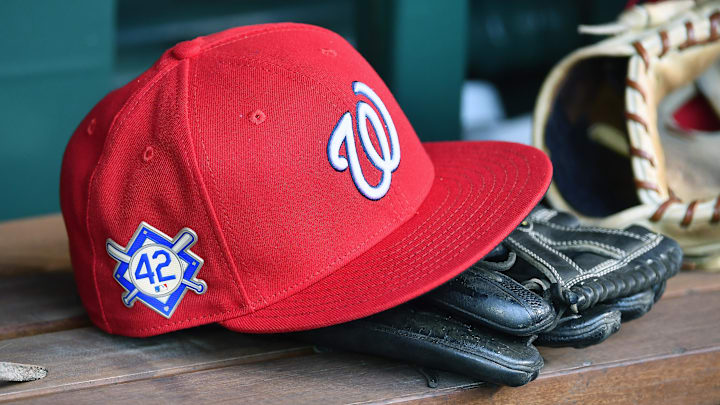 Red Washington Nationals hat on top of a black mitt