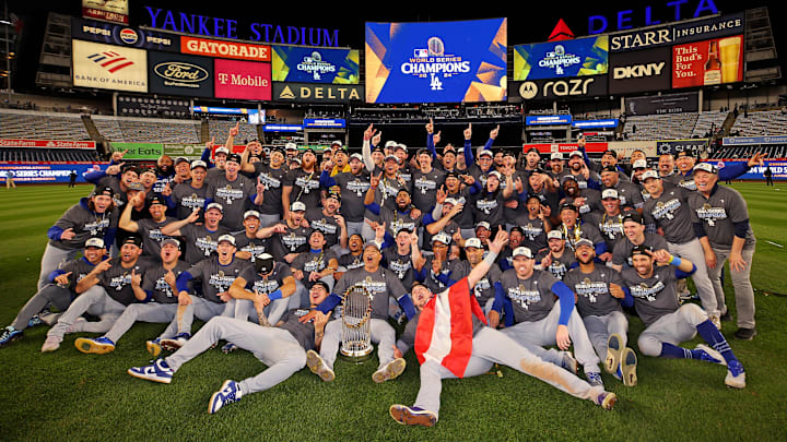Oct 31, 2024; New York, New York, USA; The Los Angeles Dodgers pose for a picture with the Commissioner’s Trophy after beating the New York Yankees in game four to win the 2024 MLB World Series at Yankee Stadium. Mandatory Credit: Brad Penner-Imagn Images