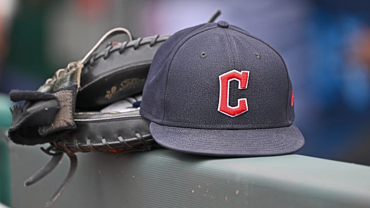 Jun 27, 2024; Kansas City, Missouri, USA; A general view a Cleveland Guardians hat and glove on the dugout railing  before a game against the Kansas City Royals at Kauffman Stadium. Mandatory Credit: Peter Aiken-Imagn Images